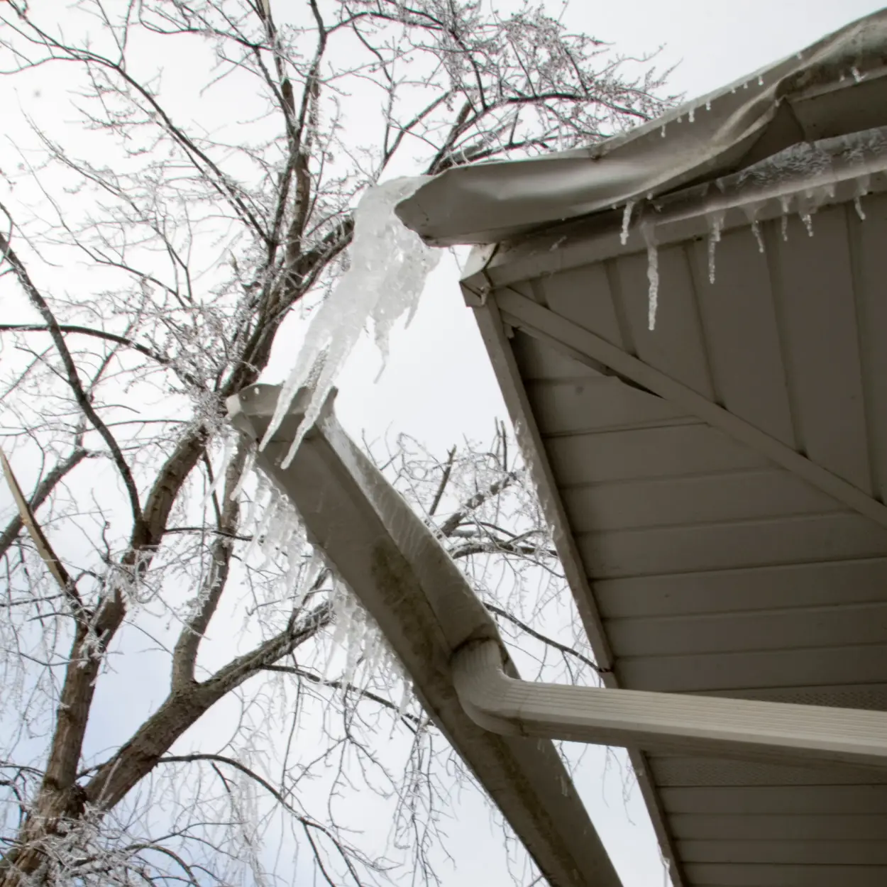 Detached residential gutter with ice accumulation during winter