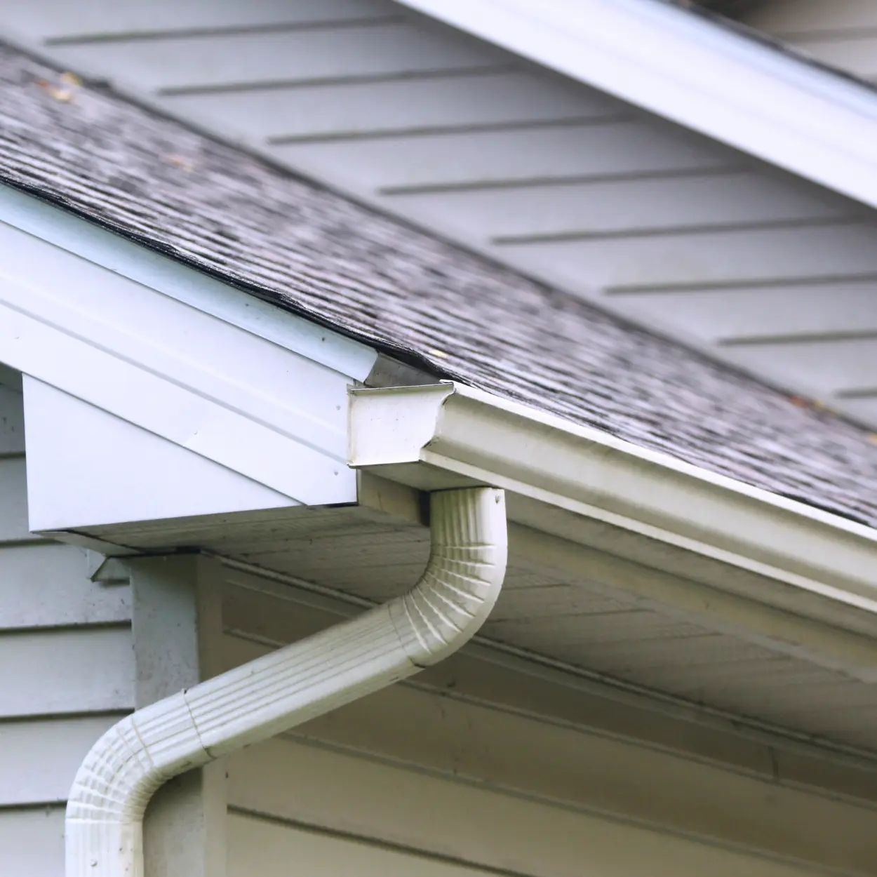 Residential home exterior gutters and asphalt shingle roof.