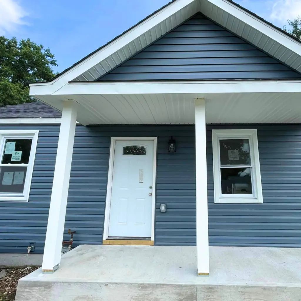 Newly installed blue vinyl siding on a residential home.